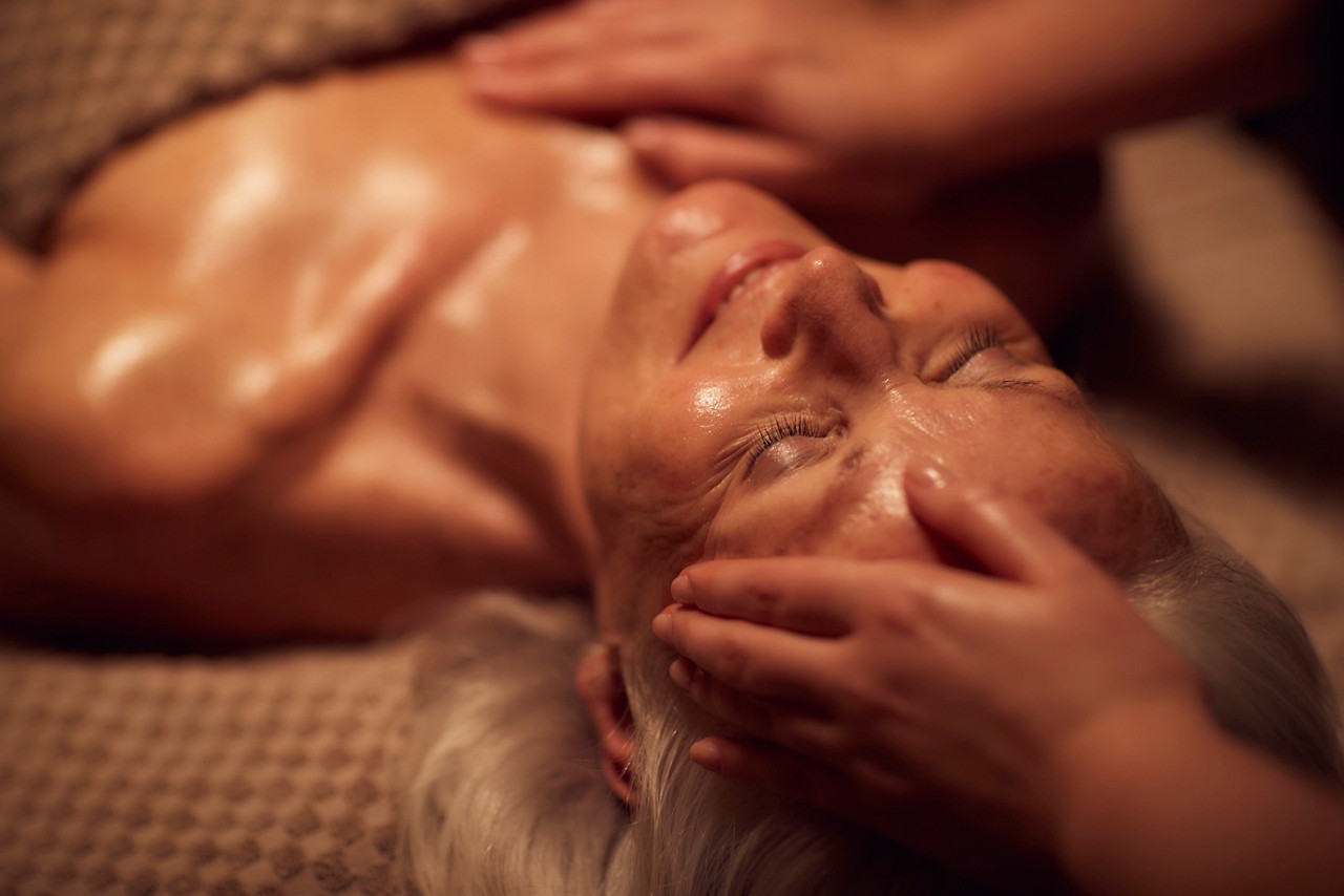 Spa therapist giving a woman a facial treatment.
